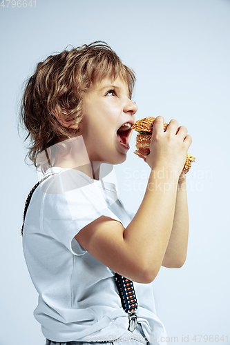 Image of Pretty young boy in casual clothes on white studio background