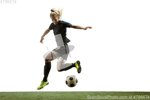 Image of Female soccer player kicking ball at the stadium