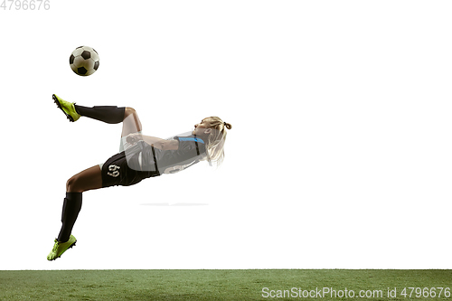 Image of Female soccer player kicking ball at the stadium