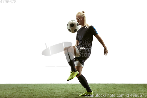 Image of Female soccer player kicking ball at the stadium