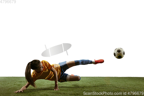 Image of Female soccer player kicking ball at the stadium