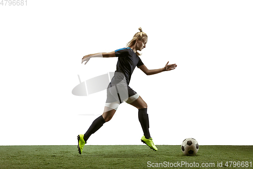 Image of Female soccer player kicking ball at the stadium