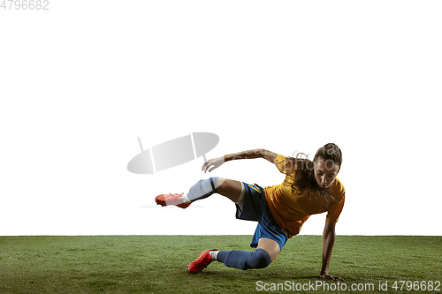 Image of Female soccer player kicking ball at the stadium