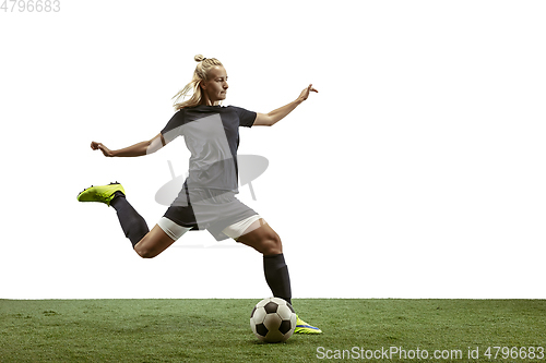 Image of Female soccer player kicking ball at the stadium