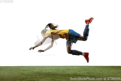 Image of Female soccer player kicking ball at the stadium