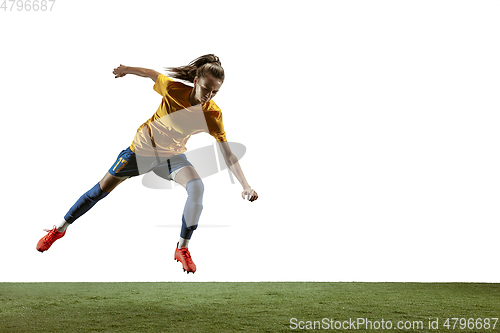 Image of Female soccer player kicking ball at the stadium