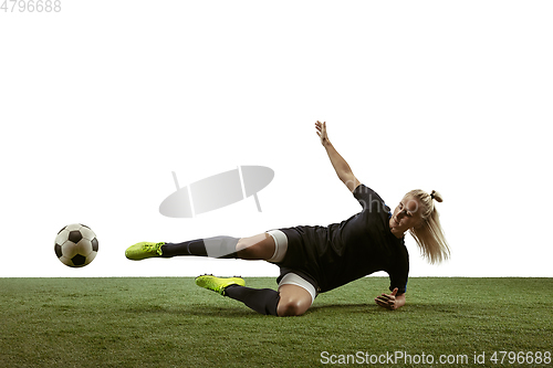 Image of Female soccer player kicking ball at the stadium