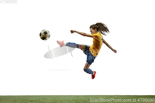 Image of Female soccer player kicking ball at the stadium