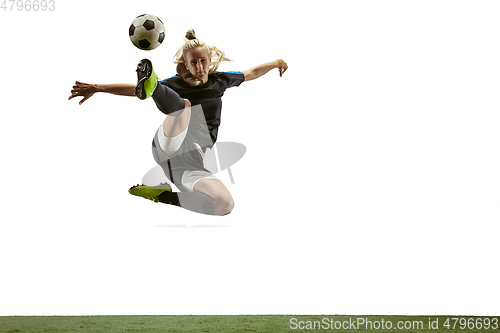 Image of Female soccer player kicking ball at the stadium