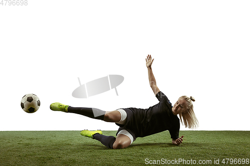 Image of Female soccer player kicking ball at the stadium