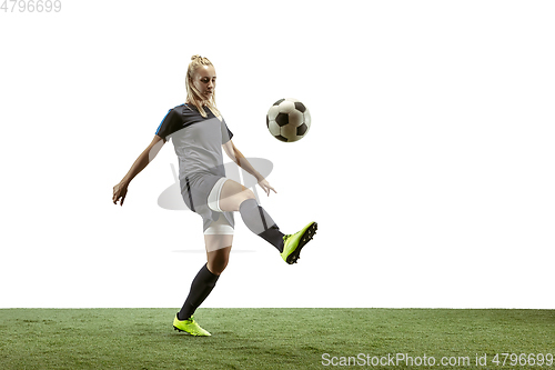 Image of Female soccer player kicking ball at the stadium