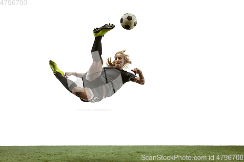 Image of Female soccer player kicking ball at the stadium