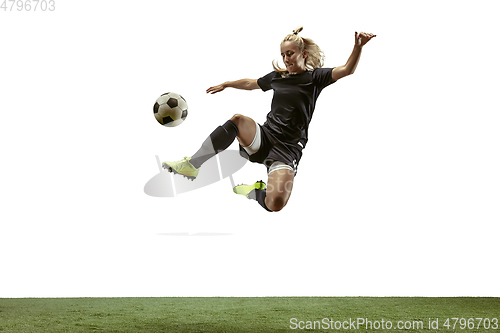 Image of Female soccer player kicking ball at the stadium