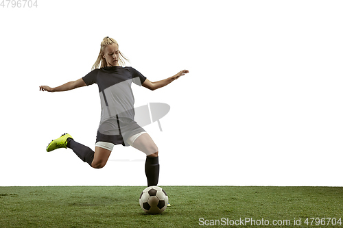 Image of Female soccer player kicking ball at the stadium