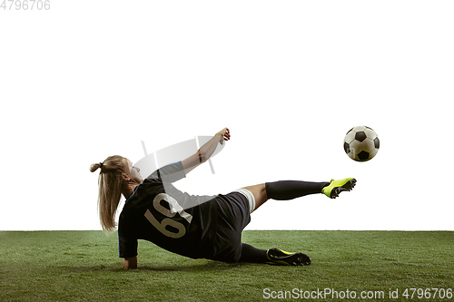 Image of Female soccer player kicking ball at the stadium