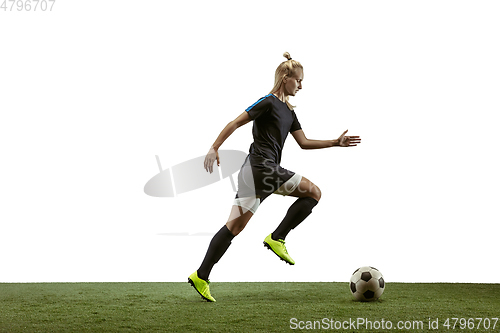 Image of Female soccer player kicking ball at the stadium