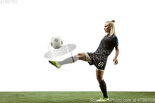 Image of Female soccer player kicking ball at the stadium