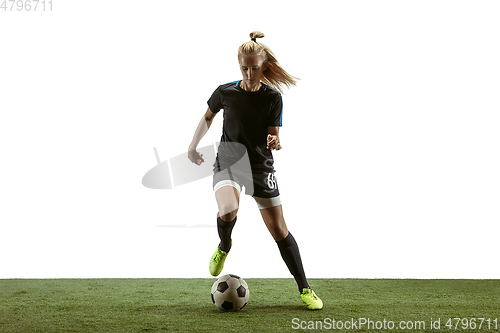 Image of Female soccer player kicking ball at the stadium