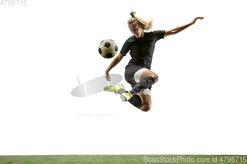Image of Female soccer player kicking ball at the stadium