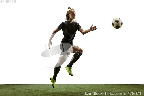 Image of Female soccer player kicking ball at the stadium