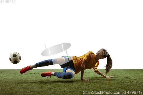 Image of Female soccer player kicking ball at the stadium