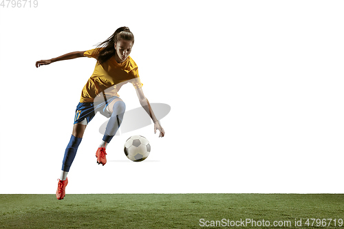 Image of Female soccer player kicking ball at the stadium