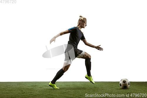 Image of Female soccer player kicking ball at the stadium