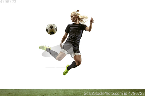 Image of Female soccer player kicking ball at the stadium