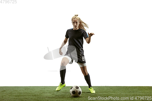 Image of Female soccer player kicking ball at the stadium