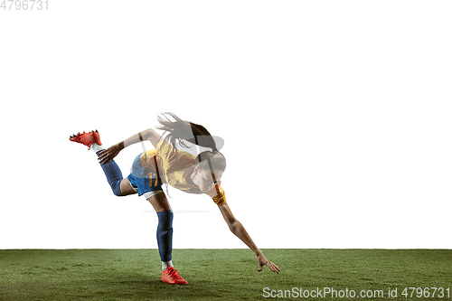 Image of Female soccer player kicking ball at the stadium