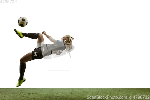 Image of Female soccer player kicking ball at the stadium