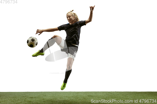 Image of Female soccer player kicking ball at the stadium