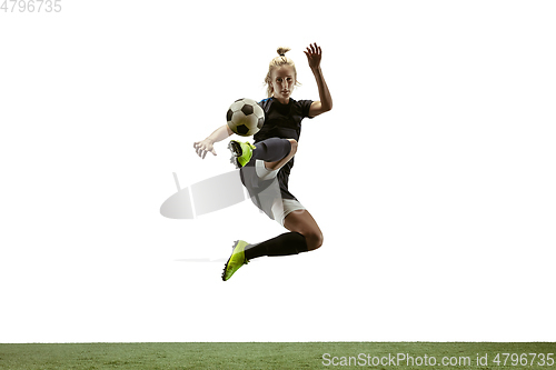 Image of Female soccer player kicking ball at the stadium