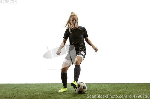 Image of Female soccer player kicking ball at the stadium