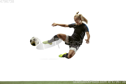 Image of Female soccer player kicking ball at the stadium