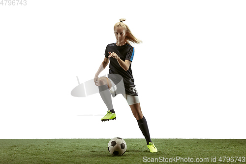 Image of Female soccer player kicking ball at the stadium