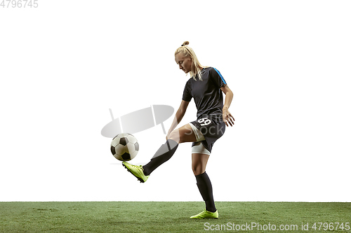 Image of Female soccer player kicking ball at the stadium