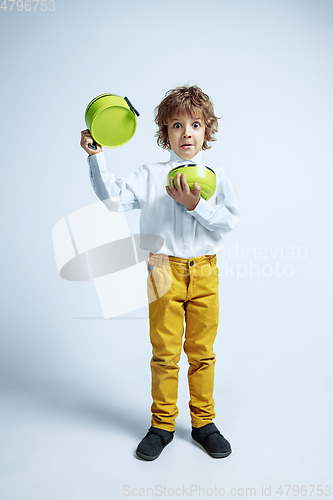 Image of Pretty young boy in casual clothes on white studio background