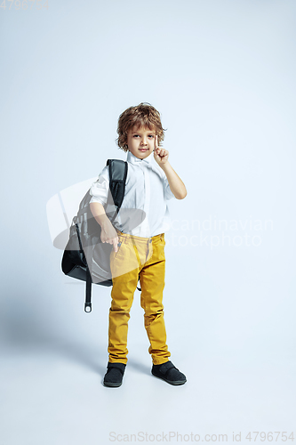 Image of Pretty young boy in casual clothes on white studio background