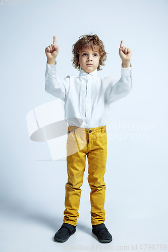 Image of Pretty young boy in casual clothes on white studio background