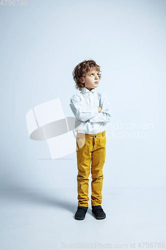 Image of Pretty young boy in casual clothes on white studio background