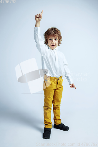 Image of Pretty young boy in casual clothes on white studio background