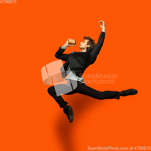 Image of Man in casual office style clothes jumping isolated on studio background