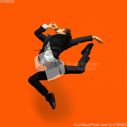 Image of Man in casual office style clothes jumping isolated on studio background