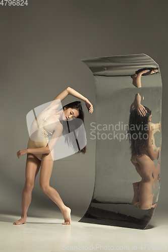 Image of Young and stylish modern ballet dancer on brown background