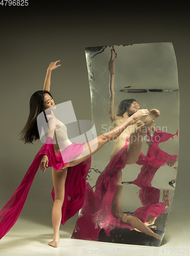 Image of Young and stylish modern ballet dancer on brown background