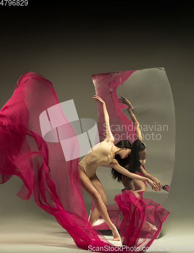 Image of Young and stylish modern ballet dancer on brown background