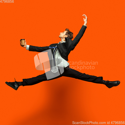 Image of Man in casual office style clothes jumping isolated on studio background