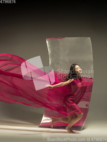 Image of Young and stylish modern ballet dancer on brown background