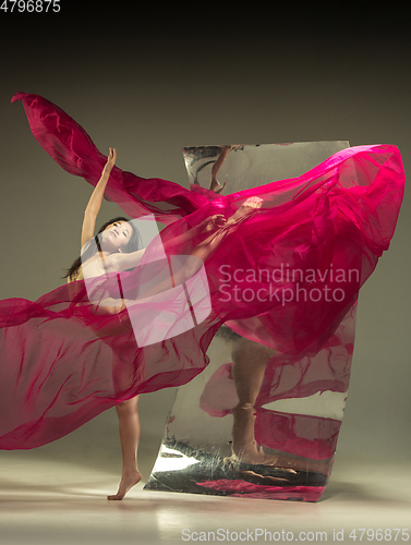 Image of Young and stylish modern ballet dancer on brown background